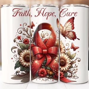 Può includere: Un bicchiere bianco con un nastro rosso, girasoli e una farfalla. Il testo "Faith, Hope, Cure" è stampato sul bicchiere.