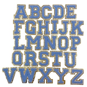 May include: A set of 26 blue felt letters with gold glitter trim. The letters are uppercase and are arranged in alphabetical order.