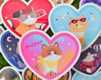 Puede incluir: Un conjunto de pegatinas en forma de corazón con lindos gatos en varias poses. Las pegatinas tienen un acabado brillante y son perfectas para agregar un toque de fantasía a las computadoras portátiles, botellas de agua o diarios. Las pegatinas presentan una variedad de colores, incluyendo rosa, azul, rojo y amarillo.