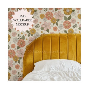 May include: A PSD mockup of a floral wallpaper design with a mustard yellow headboard and white bedding. The wallpaper features a repeating pattern of pink, orange, and yellow flowers on a cream background.