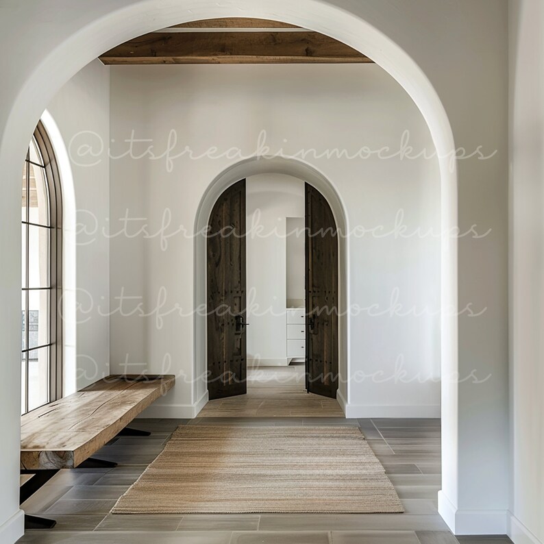 Puede incluir: Un pasillo blanco con un banco de madera, una alfombra y dos puertas arqueadas de madera. El pasillo tiene un techo blanco con vigas de madera expuestas.