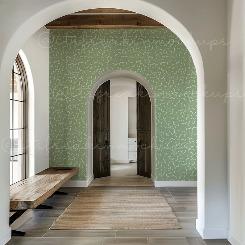 Puede incluir: Un pasillo con papel tapiz verde estampado y un banco de madera. El pasillo tiene una puerta arqueada con dos puertas de madera que conducen a otra habitaci&oacute;n.