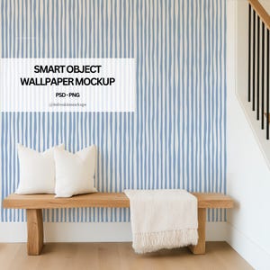 Peut inclure: Un banc en bois avec deux oreillers blancs et une couverture crème est placé devant un papier peint à rayures bleues et blanches. Le texte "SMART OBJECT WALLPAPER MOCKUP" est affiché sur le papier peint.