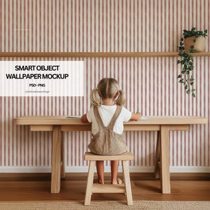 Op de afbeelding: Een kind zit aan een licht houten bureau en kruk en schrijft. De achtergrond is een gestreept behang in roze en wit. Een plank met een plant in een pot is aan de muur bevestigd. De afbeelding bevat tekst: "SMART OBJECT WALLPAPER MOCKUP".