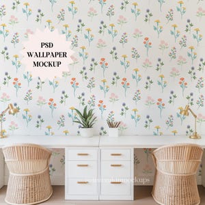 May include: A home office setup featuring a white desk with two rattan chairs. The backdrop is a floral wallpaper with colorful flowers. The desk has drawers, gold lamps, and a potted plant. Text on the wall says "PSD WALLPAPER MOCKUP".