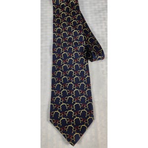 May include: Navy blue tie with a repeating pattern of gold and red interlocking shapes. The tie is made of a smooth fabric and has a classic pointed end. The pattern is evenly spaced across the tie's surface.