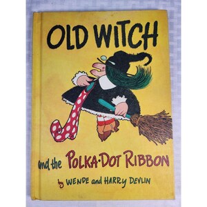 May include: A hardcover children's book titled Old Witch and the Polka-Dot Ribbon by Wende and Harry Devlin. The yellow cover features a cartoon illustration of a witch with green hair, a black dress, and a long red ribbon with white polka dots.