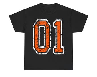 May include: Black t-shirt featuring the number "01" in distressed orange with a white outline. The design has a vintage, worn look. The shirt is a classic crew neck style.
