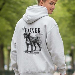 May include: A light gray hoodie with a hood and a graphic of a Boxer dog. The dog graphic is black and white with the word "Boxer" above it. The hoodie also has the words "Loyal - Bold - Devoted" printed below the dog graphic.