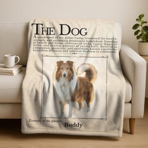 Puede incluir: Una manta beige con una imagen enmarcada de un perro Collie con pelaje marrón y blanco. El texto "THE DOG" está en la parte superior, con texto descriptivo debajo. El texto "Example of the species: Buddy" está en la parte inferior.