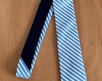May include: A blue and white striped tie with a black lining. The tie has a diagonal stripe pattern.