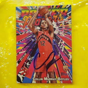 May include: A basketball trading card featuring Collin Murray-Boyles in a red Raptors uniform, number 12, shooting a basketball. The card has a colorful background with the words "Power Players" at the top. The card is signed.