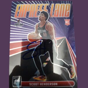 Peut inclure: Une carte de collection de basket-ball représentant Scoot Henderson, joueur de basket-ball des Portland Trail Blazers. La carte est une carte de recrue et présente un design holographique avec une route rouge et blanche. La carte est signée par Scoot Henderson.