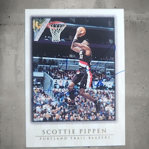 Puede incluir: Tarjeta de baloncesto con Scottie Pippen de los Portland Trail Blazers en acción, a punto de lanzar un balón. La tarjeta tiene un borde blanco e incluye el nombre del jugador y el logotipo del equipo.