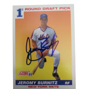 May include: A baseball card featuring Jeromy Burnitz of the New York Mets. The card has a photo of Burnitz in his Mets uniform, with his signature in blue ink. Text includes "1st Round Draft Pick" and "Score 91".