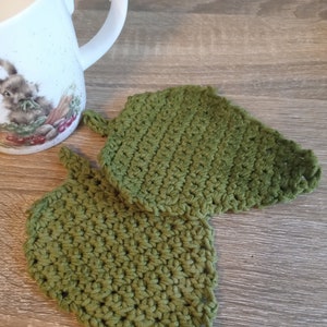 May include: Two green crocheted leaf-shaped pot holders.