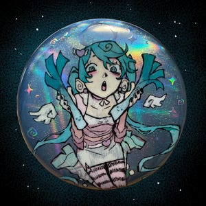 May include: A round, holographic button featuring a cartoon girl with teal hair and a surprised expression. She's holding green vegetables. The button has a pink and white dress, and is set against a dark, starry background.