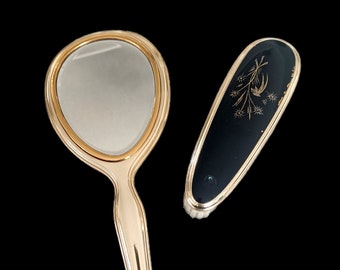 Hollow metal and bronze hand mirror, gold and black color and its brush 1950 collection