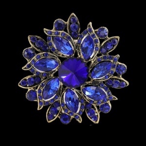 ディープブルークリスタルをセットしたゴールド/ブロンズカラーの花の形をした、最高品質の透かし彫りペンダント/ブローチ