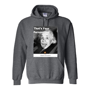Puede incluir: Una sudadera con capucha gris oscuro con una foto en blanco y negro de Albert Einstein sacando la lengua. El texto "That's Your Perspective" está por encima de la foto y "Albert Einstein" está por debajo de la foto.