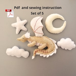 May include: A set of five felt ornaments, including a dragon, a star, a crescent moon, and two clouds. The dragon is beige with red stitching and white wings. The ornaments are for sewing and come with a PDF instruction guide.  Set of 5.