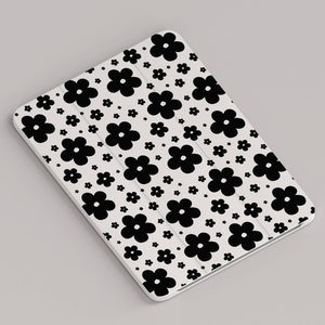 May include: White tablet case with a black and white floral pattern. The case is covered in small black flowers on a white background.
