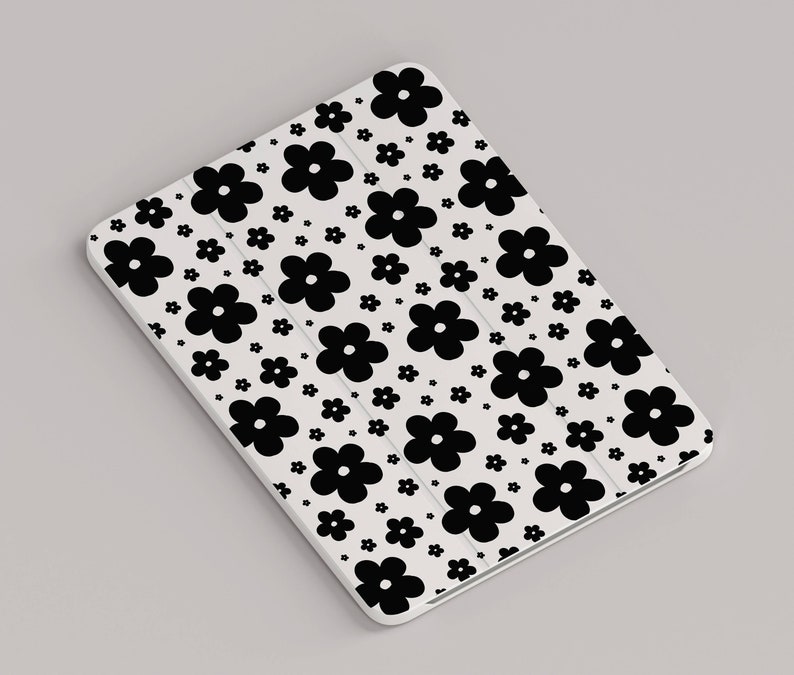 May include: White tablet case with a black and white floral pattern. The case is covered in small black flowers on a white background.