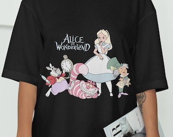 Może przedstawiać: Czarny, oversize'owy T-shirt z nadrukiem graficznym postaci z Alicji w Krainie Czarów, w tym Alicji, Szalonego Kapelusznika, Kota z Cheshire i Marca. Tekst "Alicja w Krainie Czarów" jest nadrukowany nad postaciami.