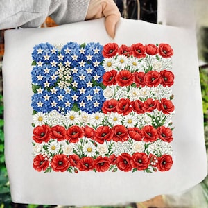May include: A white rectangular print featuring a floral American flag design. The flag's blue field is composed of blue hydrangeas and white stars. Red poppies and white daisies form the stripes.
