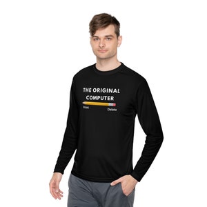 Peut inclure: T-shirt noir à manches longues avec le texte "THE ORIGINAL COMPUTER" au-dessus d'un crayon jaune. Le crayon porte les mots "Print" et "Delete". Le t-shirt est porté par une personne.
