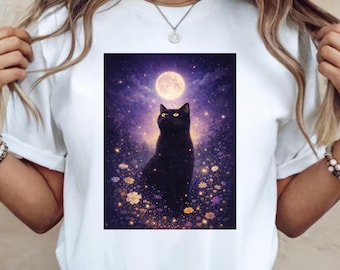 May include: White t-shirt with a graphic of a black cat looking up at a full moon in a starry night sky. The cat is set amongst yellow and purple flowers. The design has a whimsical, magical theme.