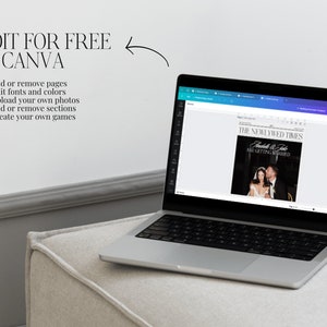 Pu&ograve; includere: Un computer portatile che mostra un modello di annuncio di matrimonio sullo schermo. L'annuncio &egrave; intitolato "The Newlywed Times" e presenta una foto di una coppia in bianco e nero. Il testo dell'annuncio recita "Fredele & Jake are getting married". Il laptop &egrave; su una superficie grigio chiaro.