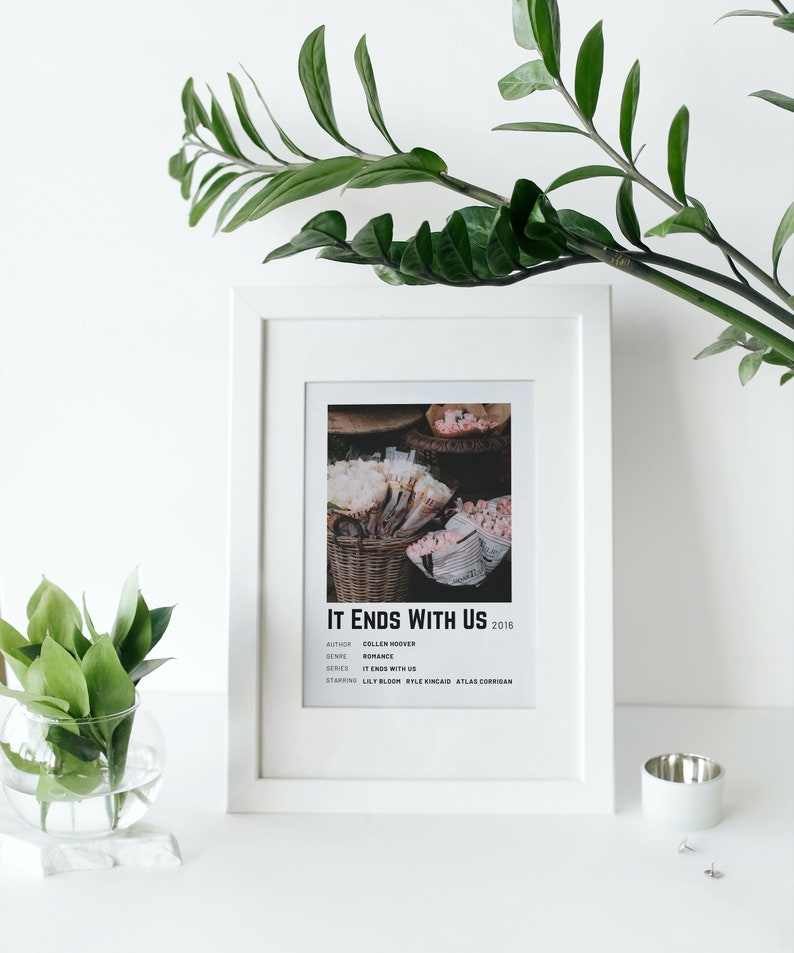 Może przedstawiać: Biała oprawa z czarno-białym plakatem dla książki "It Ends With Us" Colleen Hoover. Plakat zawiera tytuł książki, autora, gatunek, serię i aktor&oacute;w grających gł&oacute;wne role. Plakat przedstawia zdjęcie koszyka z r&oacute;żowymi kwiatami.