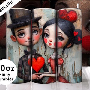 Puede incluir: Un vaso skinny de 20 oz con una ilustración colorida de una pareja. El hombre lleva un sombrero negro y una chaqueta a cuadros. La mujer lleva un vestido rojo y tiene el pelo largo y negro. El fondo es una acuarela azul claro y verde. El vaso es perfecto para contener bebidas calientes o frías.