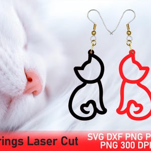 Puede incluir: Pendientes con forma de gato, uno negro y otro rojo, cuelgan de ganchos plateados con detalles dorados. Los pendientes cortados con láser presentan un contorno simple de un gato sentado. El fondo es una imagen suave y borrosa de un gato blanco.