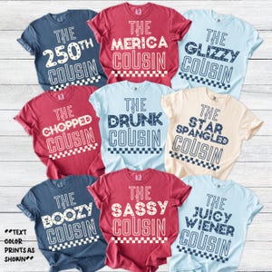 May include: A collection of short-sleeved t-shirts in various colors, each featuring a unique text design. The shirts display phrases like "The 250th Cousin," "The 'Merica Cousin," and "The Glizzy Cousin" in white text. The text color prints as shown.