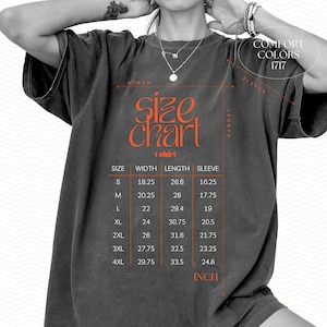 May include: Dark grey t-shirt with an orange size chart graphic. The chart displays measurements in inches for width, length, and sleeve length for sizes S through 4XL. The text "COMFORT COLORS 1717" is also visible.