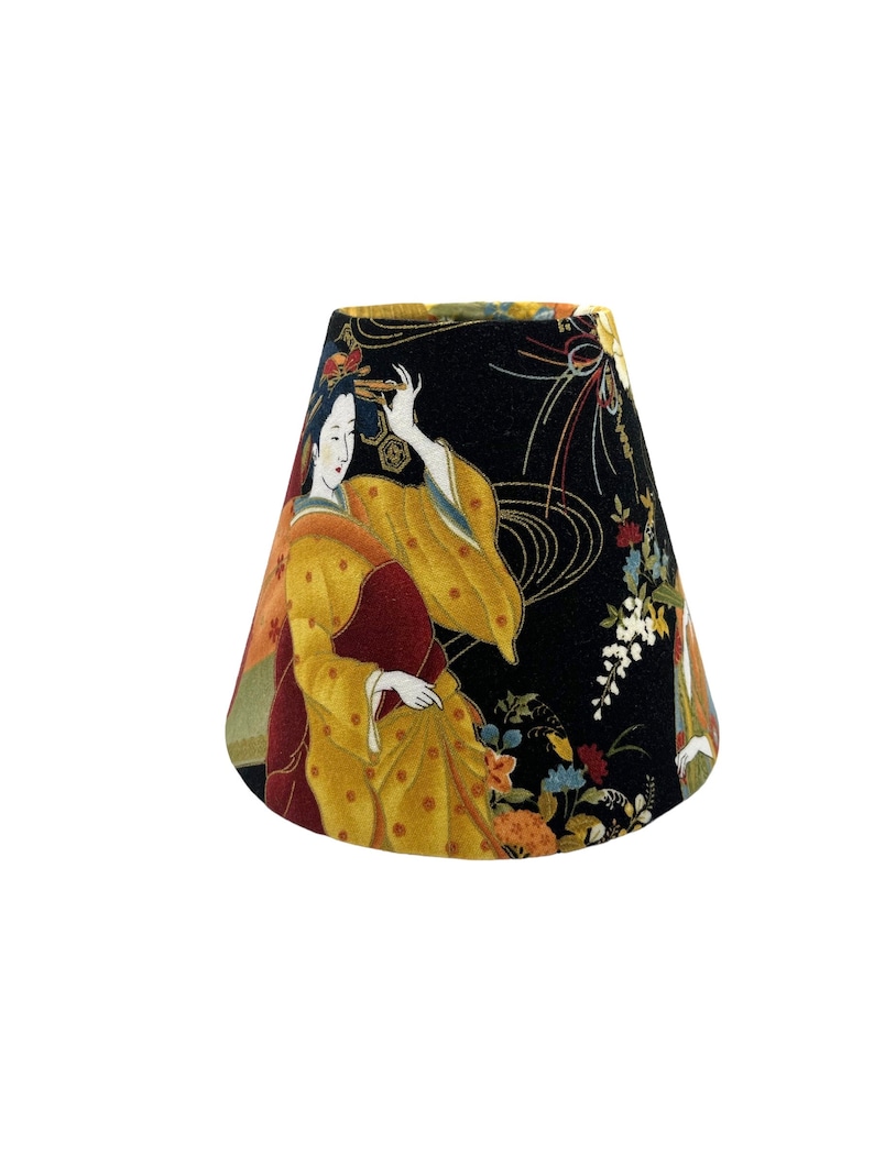 May include: A black lampshade with a conical shape features a colourful Japanese-inspired print of a woman in a yellow and red kimono with floral accents. The background is black with gold and white swirling patterns.