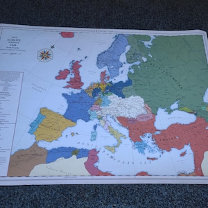 May include: A vintage map of Europe in 1948, showing the borders of the countries at the time. The map is printed on a white background with colored borders for each country. The map includes the text "Map of Europe at the Beginning of 1948 The Rise of the Iron Curtain" and a compass rose.