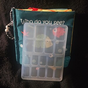 May include: A clear plastic storage box with 15 compartments. The box has the words "WHS MARKERS" and "1x1.5" printed on the bottom.