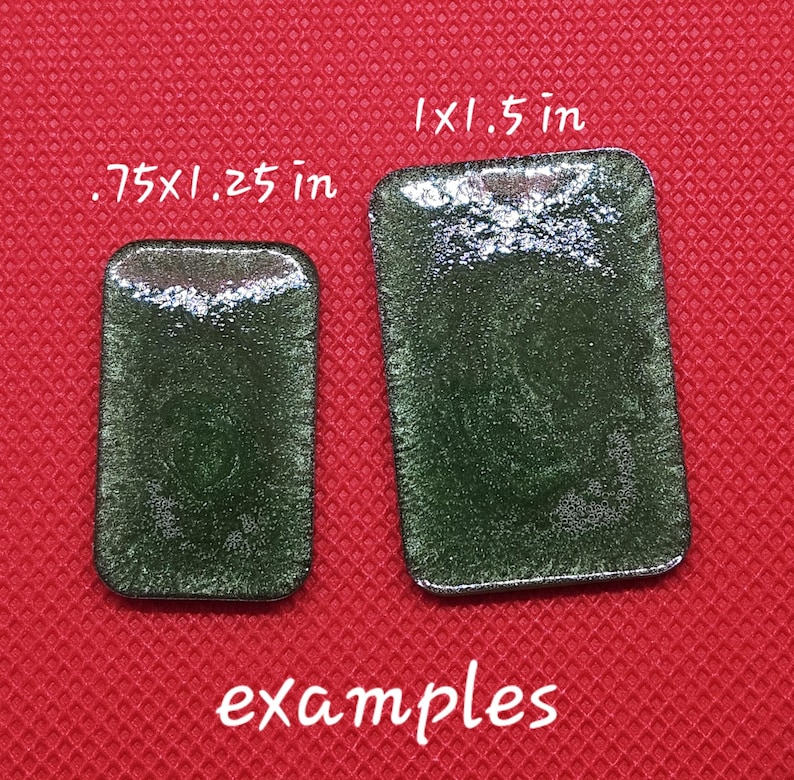 May include: Two rectangular green glass tiles with a sparkly finish. The smaller tile measures .75 x .25 inches and the larger tile measures 1 x 1.5 inches.  Examples.