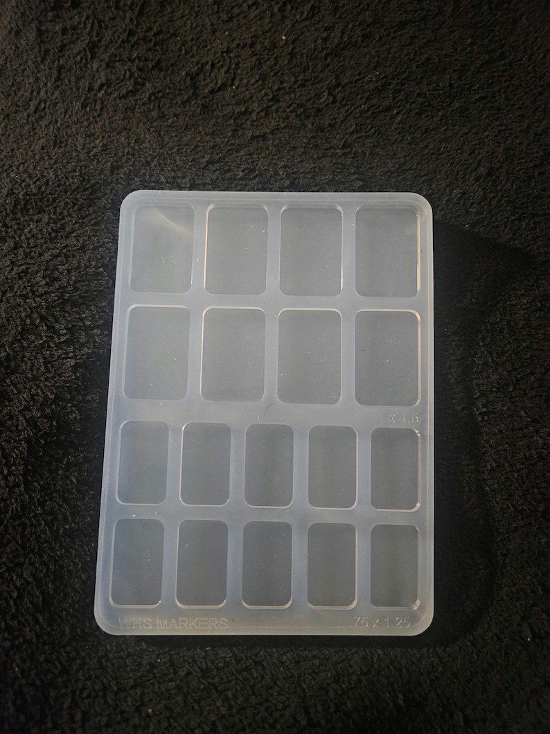 May include: A clear plastic mold with 16 rectangular compartments. The mold is labeled "Mini Markers" and "7.5 x 1.25".