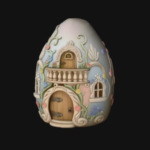 Può includere: Una casa decorativa a forma di uovo con esterno color crema e azzurro chiaro, caratterizzata da viticci scolpiti, piccoli fiori color pastello, due porte in legno con cerniere in metallo, un balcone con balaustra e finestre ad arco bianche.