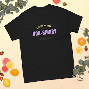 May include: Black t-shirt with the text "Limited Edition Non-Binary -Classic- " in yellow and purple.