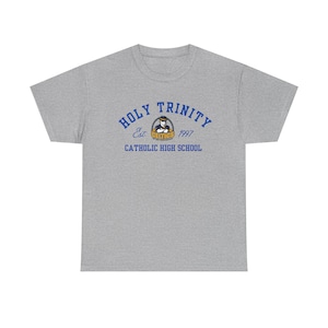 Può includere: Maglietta grigia a maniche corte con un logo blu e oro che dice "Holy Trinity Catholic High School" con il testo "Est. 1997" sotto.