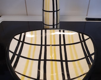 May include: A black and yellow ceramic vase and a matching black and yellow ceramic bowl with a geometric pattern.