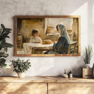 May include: A framed print depicts a tender scene of a child and a woman at a table with bread. The artwork, in warm tones, shows the figures in a rustic setting, with a soft, painterly style. The wooden frame complements the artwork's gentle aesthetic.