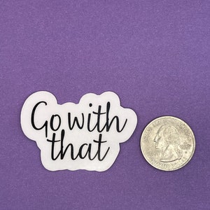 May include: White sticker with black text that reads "Go with that" on a purple background. A US quarter is next to the sticker for size reference.