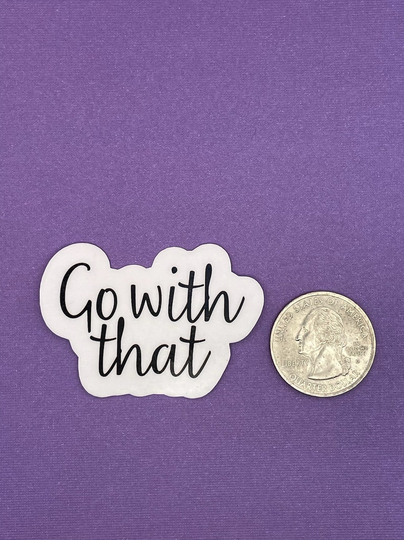 May include: White sticker with black text that reads "Go with that" on a purple background. A US quarter is next to the sticker for size reference.