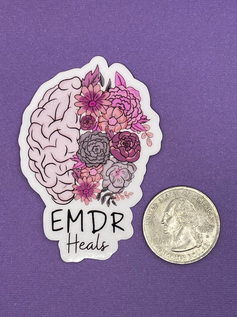 May include: A white sticker with a pink and purple floral design on a brain outline. The text "EMDR Heals" is below the design.